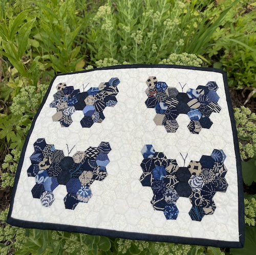 Håndsyet dækkeserviet med 4 sommerfugle i 6 kanter. 