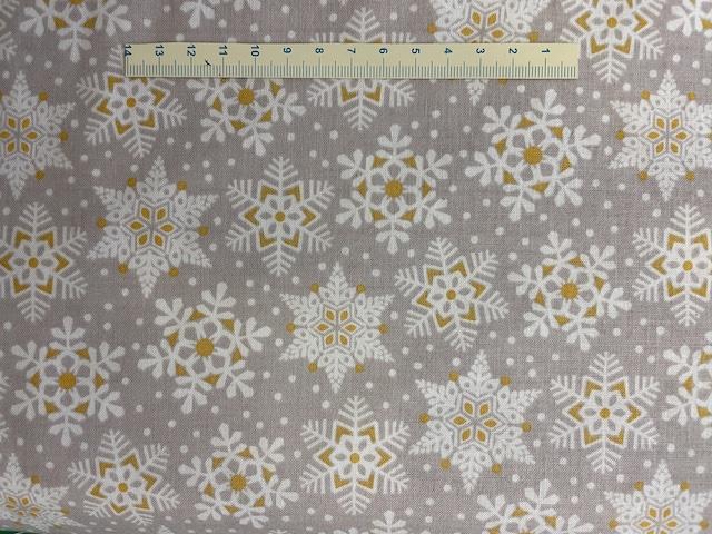 Hvide iskrystaller på grå patchworkstof med guld