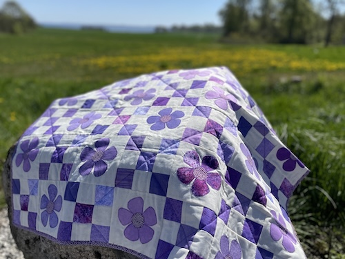 Blomster og firkanter giver smukt Østermarie baby tæppe