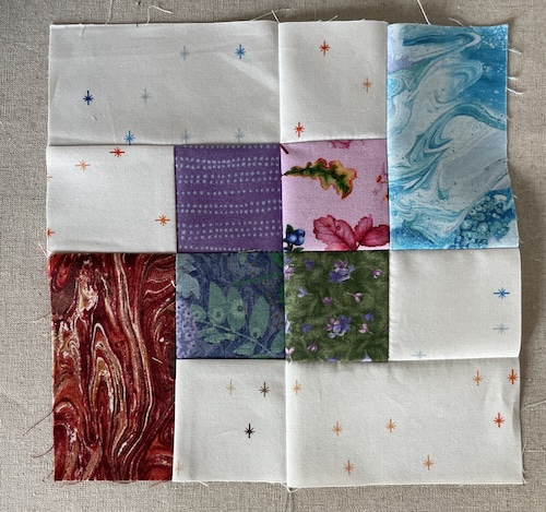 Flettet mønster på lys bund i Hellerup tæppet