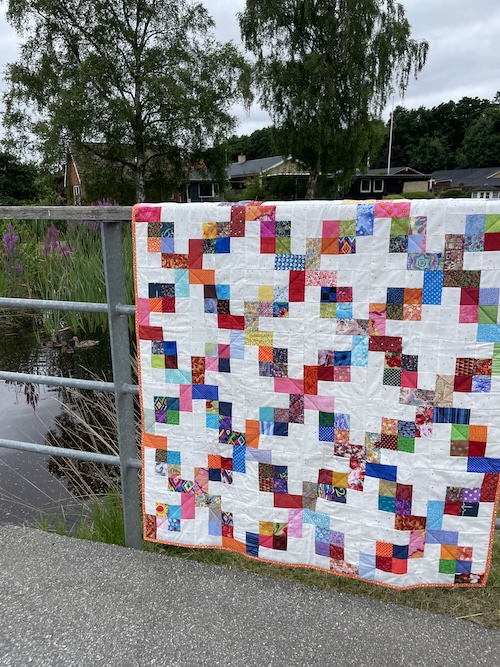 Flettet mønster på lys bund i Hellerup tæppet