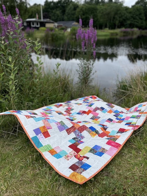 Flettet mønster på lys bund i Hellerup tæppet