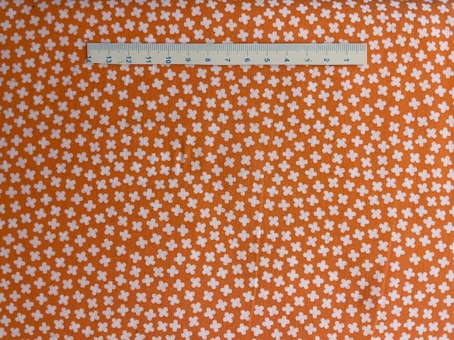 Orange patchworkstof med hvide blomster 