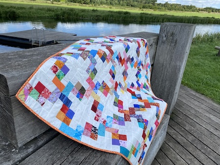 Flettet mønster på lys bund i Hellerup tæppet